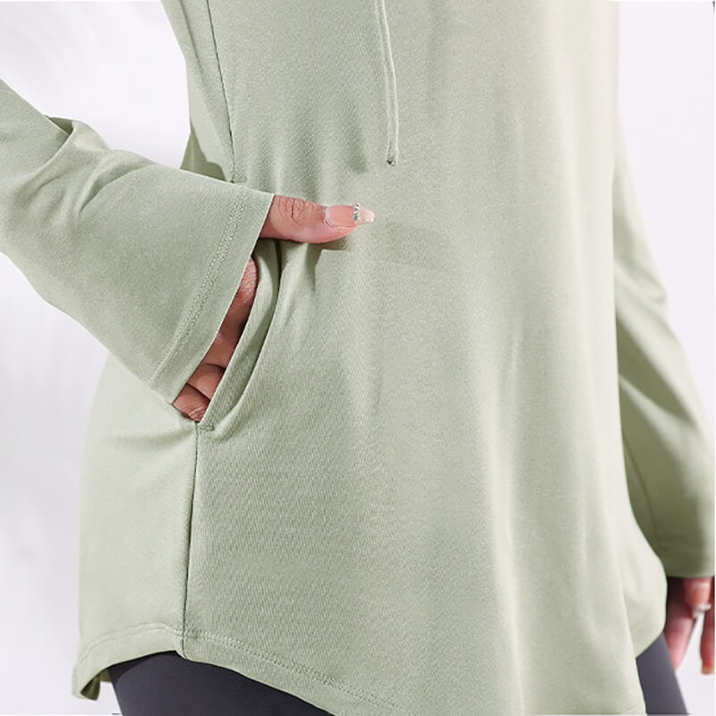 Close-up of green sports loose hooded sweatshirt for women with a focus on pocket detail, perfect for fitness and yoga.